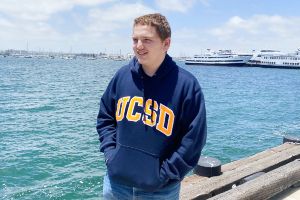 Young man teen standing on pier smiling