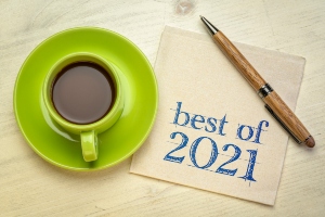 Lime green espresso cup and saucer sitting on a wooden desktop next to a pen and a napkin with "best of 2021" written on it