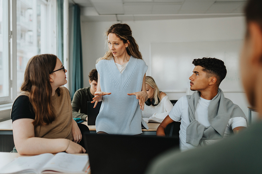 Teacher speaking with two students